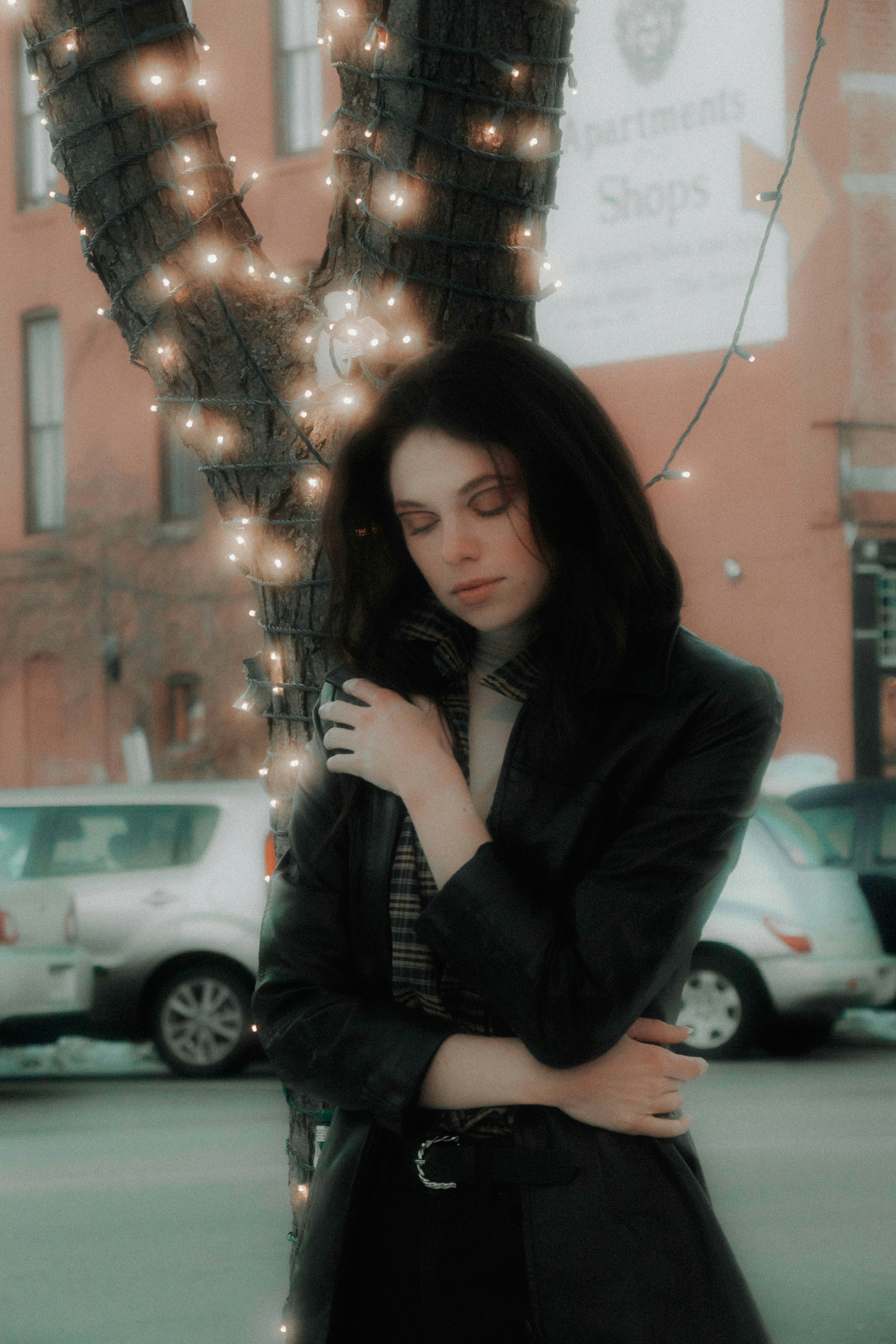 woman in black jacket holding a christmas tree